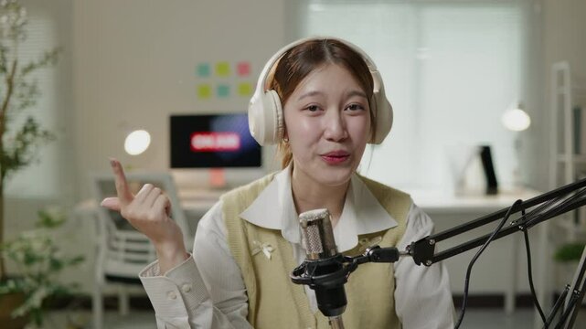 Female DJ speaker are talking in record room in pink studio for podcast radio influencer for sharing vision knowledge and experience and live broadcast streaming