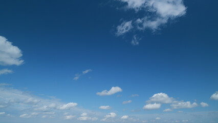 Beautiful cumulus and stratocumulus clouds visible in blue sky. Translucent cumulus clouds high up. Timelapse.
