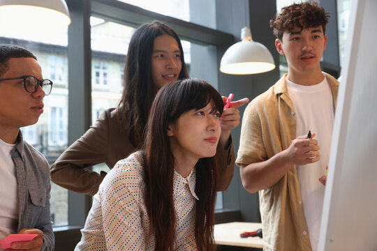 Business people looking at whiteboard during meeting