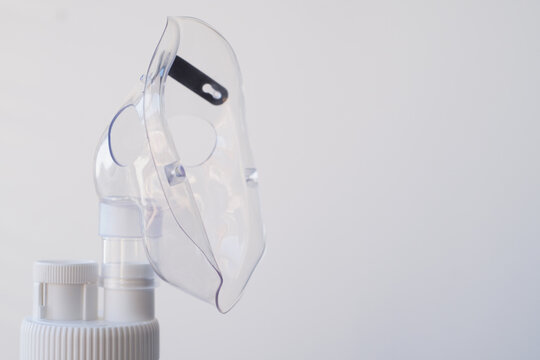 Close-up of a nebulizer mask on a white background. Treatment of colds and coughs during the sick season