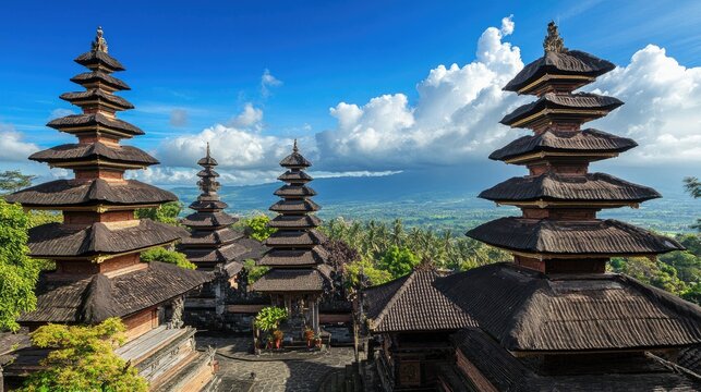 A panoramic view of Pura Besakih, Balilargest temple, with its multi-tiered pagodas standing tall against a blue sky.