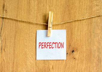 Perfection symbol. Concept word Perfection on beautiful white paper on clothespin. Beautiful wooden...