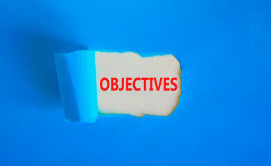 Objectives symbol. Concept word Objectives on beautiful white paper. Beautiful blue paper background. Business objectives concept. Copy space.