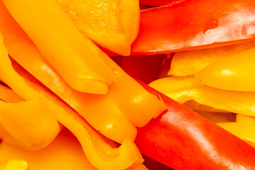 Bright slices of fresh red and yellow bell peppers close-up