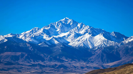 Snow-capped mountain peaks against a clear blue sky.