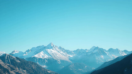 Obraz premium A panoramic view of snow-capped mountains against a clear blue sky.