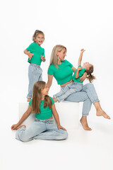 Happy modern family concept. Young mom with her daughters, posing in studio.  Enjoy time together.