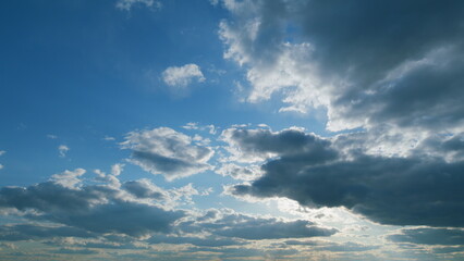 Obraz premium Clouds moves in the blue sky. Beautiful sky cloudy behind shining sun rays and eventually breaking through cloud mass. Timelapse.