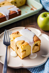 A square piece of apple pie with a moist texture and large pieces of apples on a plate