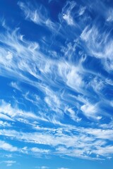 Obraz premium A plane flies high in the clear blue sky, with white clouds in the background