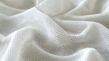 A soft, white mesh fabric drapes gently, showcasing its delicate, textured weave suitable for various applications.