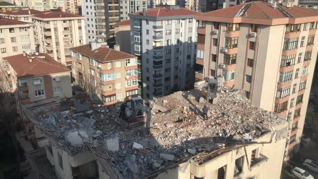 A dilapidated building in Turkish is being demolished - 4K Construction Building - Demolition digger destroying an old building - Demolition of apartment block - Medium shot of house being demolished