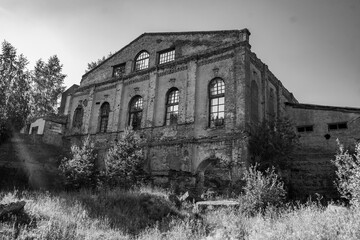 Ruins of an old abandoned factory building. Black and white photo.