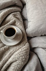 A cup of coffee in a white gray stylish bed. Cozy bedroom with sunlight. Bright modern view. Morning home comfy rituals. Breakfast in a bed.
