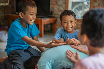 cheerful kids putting their hands over friend back while playing traditional games