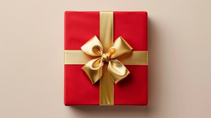 Beautifully packaged red gift box with shiny gold ribbon on a solid beige background, perfect for celebrations and special occasions, top view