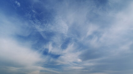 Fototapeta premium Sky And Clouds Moving In Opposite Direction With Sun. Cloudy Day Sunlight In Atmosphere In Hot Weather. Majestic Blue Sky Landscape.