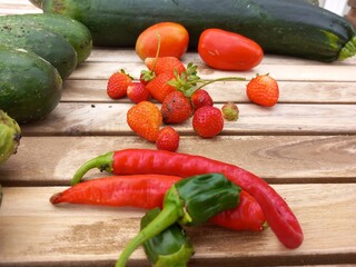 Small harvest of vegetables from a family garden on a wooden table, after gathering.