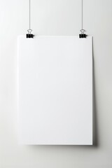 A close-up shot of a white poster hanging on a white wall, with a simple and clean design