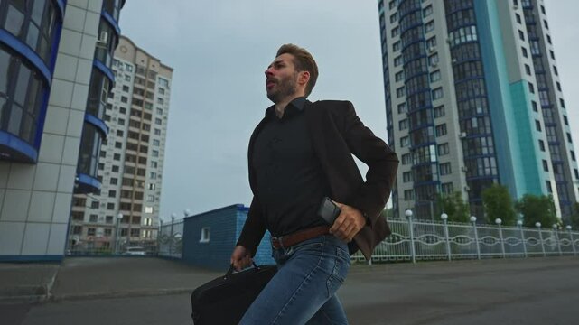 Man hurries through urban streets with briefcase on overcast day