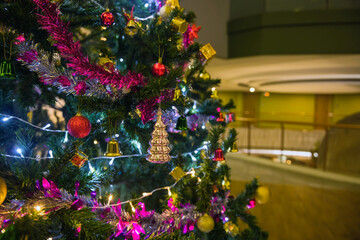 Christmas tree with balls, glowing garland and tinsel at hotel