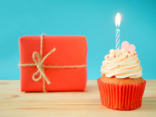 Cupcake with buttercream frosting, birthday candle and gift box