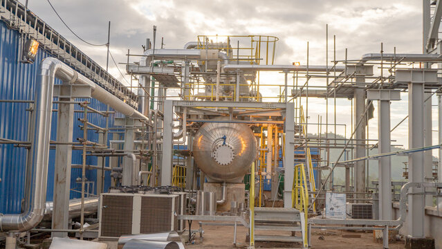 Deaerator feed water tank for coal power plant industry.A close-up of an industrial tank and piping system on a platform. The tank is made of stainless steel and is connected to a network of pipes    