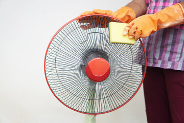 Close up hands wear gloves, hold sponge to clean electric fan. Concept, Appliance maintenance and...