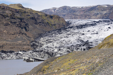 glaciel ice partly covered with volcanic ash at the glacier tongue of Sólheimajökull, South...