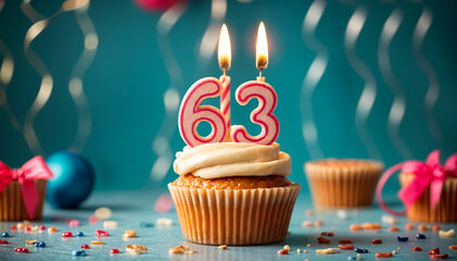 Birthday cupcake with burning lit candle with number 63. Number sixty-three for sixty-three years or sixty-third anniversary.