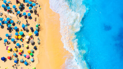 Aerial view on the beach, people and umbrellas. Vacation and adventure. Beach and blue water. Top...