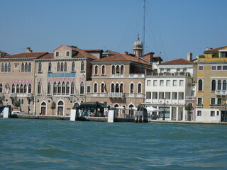 Obraz premium Romantic Venetian landscape. Tourists in a gondola on a walk along a Grand Canal in the old town. Famous historical heritage city.