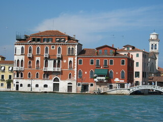 Obraz premium Romantic Venetian landscape. Tourists in a gondola on a walk along a Grand Canal in the old town. Famous historical heritage city.