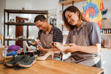 Asian workers clean and brush footwear at shoes care studio
