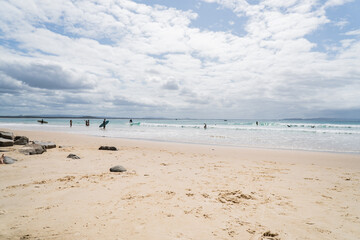 Tea Tree Bay Beach from beach angle with kids in the surf, in the national park at Noosa Heads, Queensland, Australia