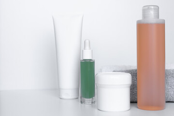 Refreshing skincare products arranged neatly on a white background with towels for self-care routine