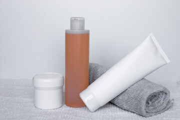 Refreshing skincare products arranged neatly on a white background with towels for self-care routine