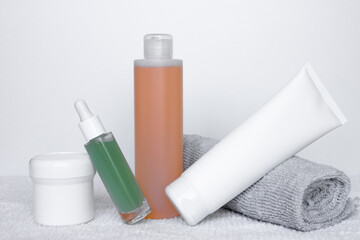Refreshing skincare products arranged neatly on a white background with towels for self-care routine