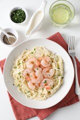 Delicious pasta with shrimps and cheese served on white table, top view