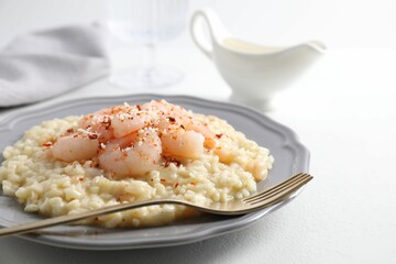 Delicious risotto with shrimps and cheese on white table, closeup