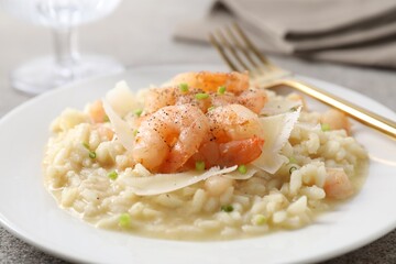 Delicious risotto with shrimps and cheese on table, closeup