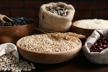 Different types of cereals, seeds and legumes on wooden table