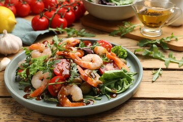 Delicious shrimp salad with vegetables on wooden table