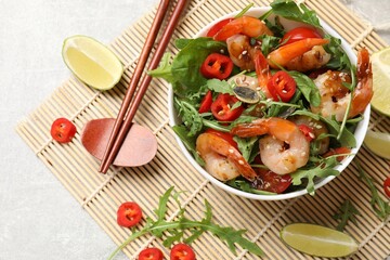 Delicious shrimp salad with vegetables in bowl served on grey table, flat lay