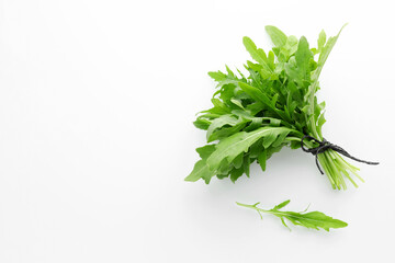 Fresh green arugula leaves on white background, flat lay. Space for text