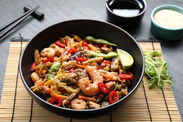Stir-fry sea food served on grey table, closeup