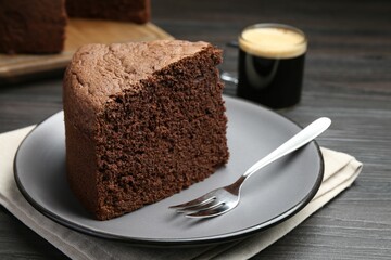 Piece of tasty chocolate sponge cake served on wooden table, closeup