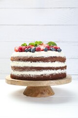 Delicious chocolate sponge cake with berries on light table