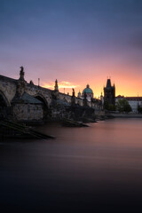 View of Charles Bridge in Prague during sunrise in the early morning with dramatic sky. Vltava river. Czech Republic.