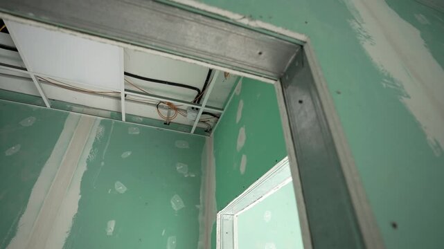 Home improvement concept. New electrical wiring is connected to the ceiling in the apartment. Wires of the electrical power system. Major renovation, plasterboard walls and suspended ceiling. drywall